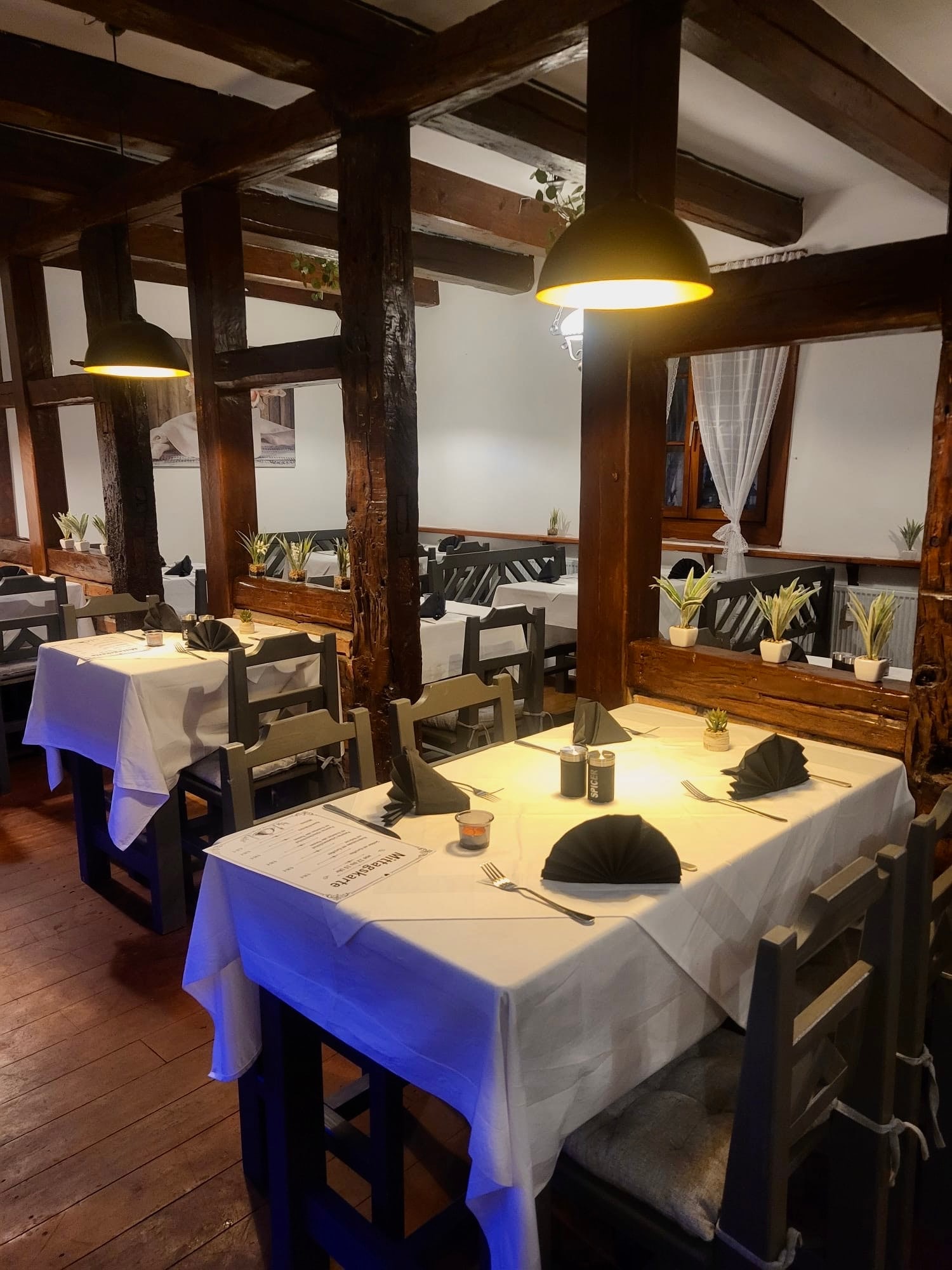Eingedeckte Tische im Gastraum am Abend
